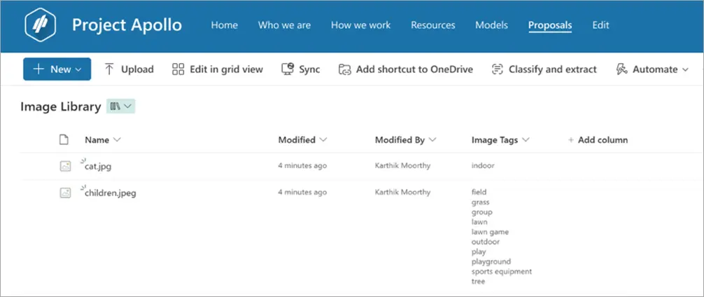 A screenshot of a document library interface titled "Project Apollo." The page displays an "Image Library" section with two files listed: "cat.jpg" and "children.jpeg." Both files are shown with details like modification time (4 minutes ago), modified by "Karthik Moorthy," and associated image tags. The tags for "cat.jpg" include "indoor," while the tags for "children.jpeg" include multiple outdoor-related tags such as "field," "grass," "group," "lawn," "lawn game," "outdoor," "play," "playground," "sports equipment," and "tree." The top navigation bar includes options like "Home," "Who we are," "How we work," "Resources," "Models," and "Proposals." Various buttons for file operations like "New," "Upload," "Sync," "Classify and extract," and "Automate" are present.